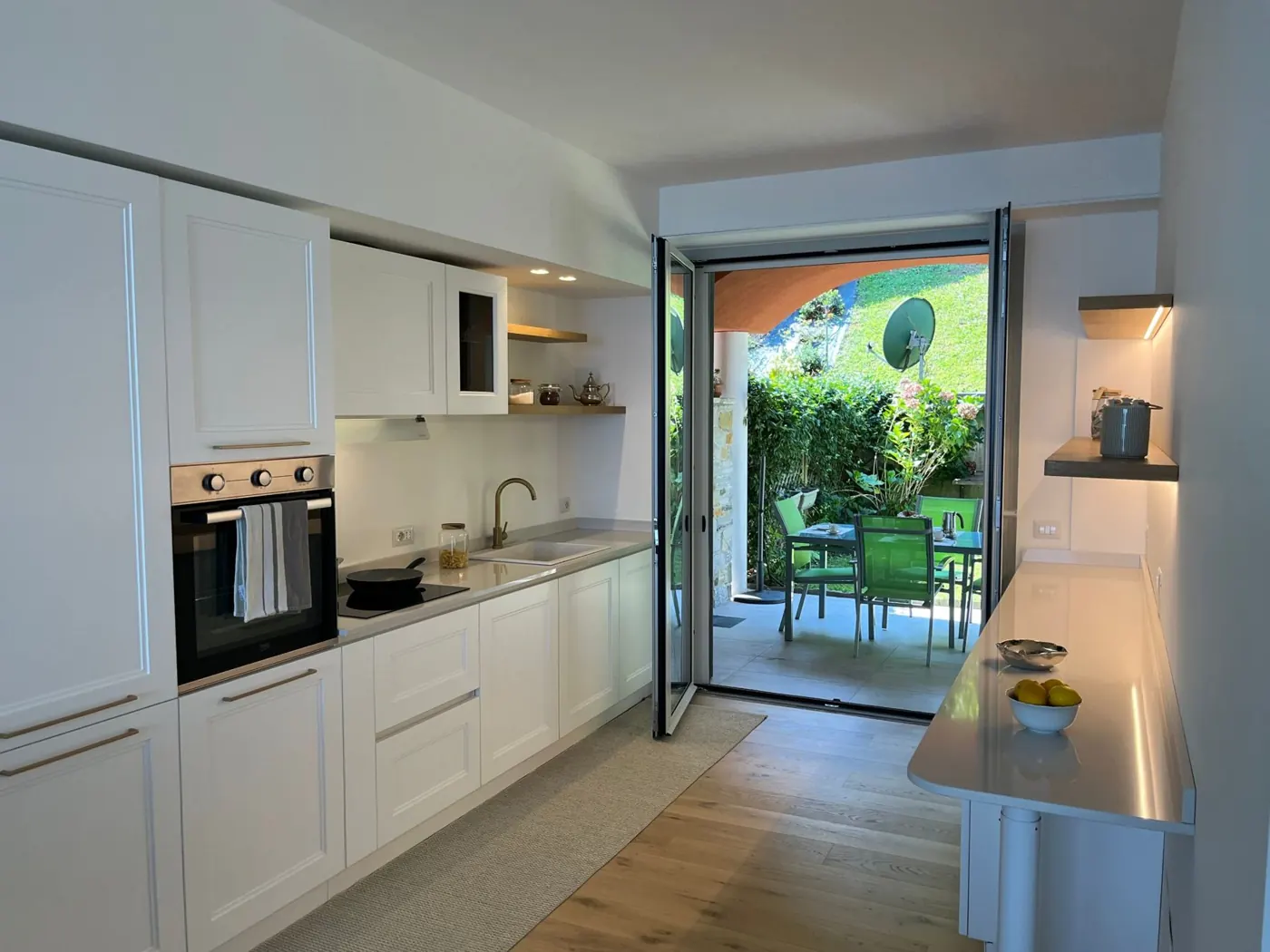 Fully equipped kitchen with oven, hob and doors to the garden